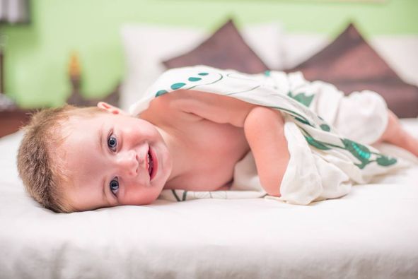 Baby wrapped in Little Poppin swaddle