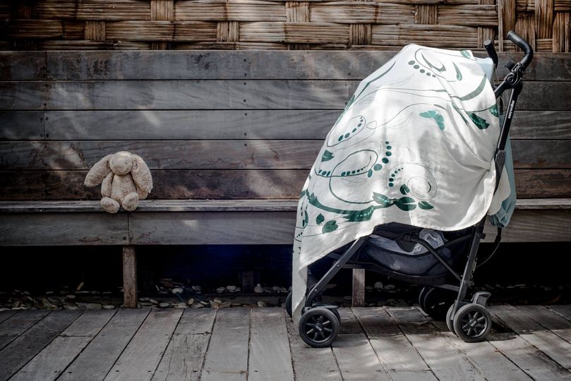 Little Poppin green swaddle on stroller